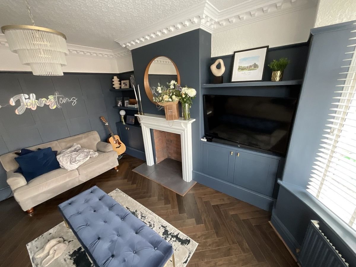 Navy painted alcove cupboards and shelving either side of a fireplace