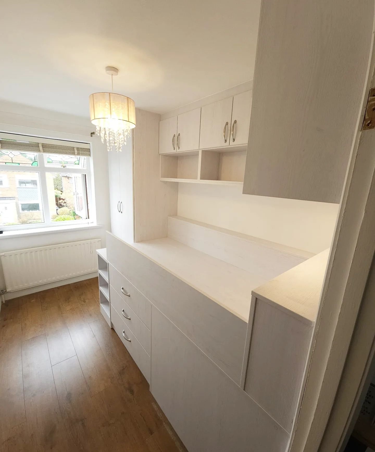 Custom made fitted cabin bed with storage under, over and to either end of a single bed built over a stair box.