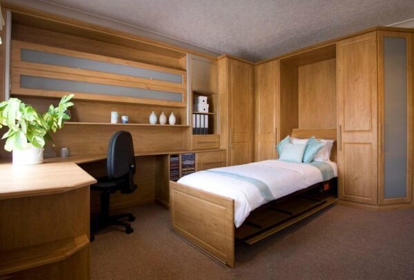 A bespoke fitted bedroom with desk, fold-down bed, shelving, wardrobes and drawers.